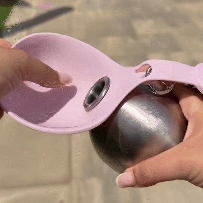 Hand holding the blush bottle by its carry loop